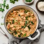 chicken and asparagus pasta in a skillet with the words high protein chicken orzo
