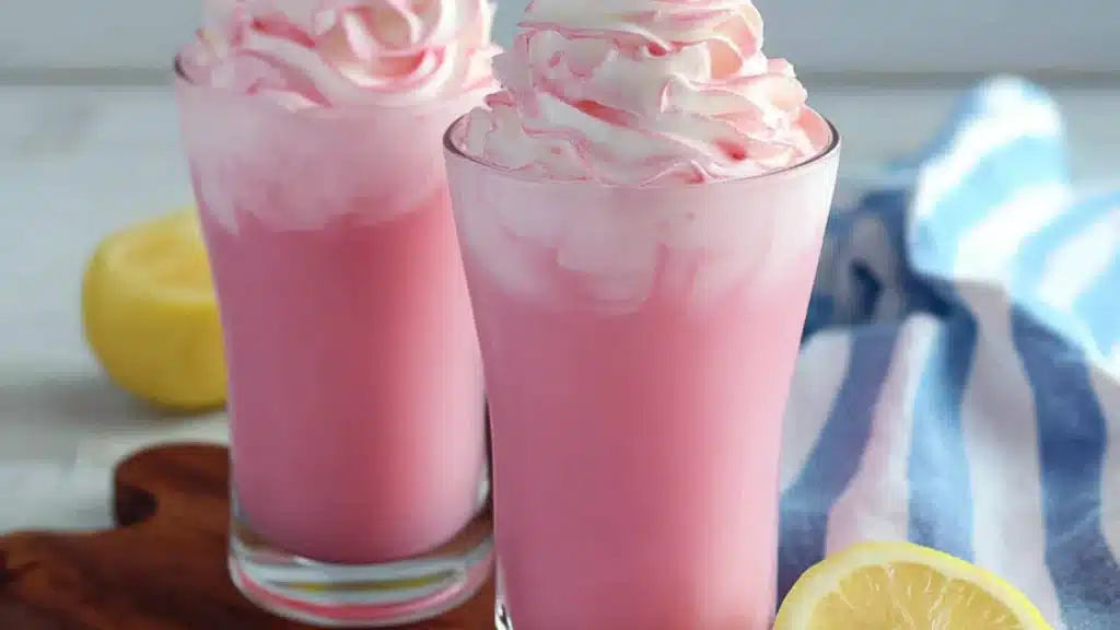 two glasses filled with whipped pink lemonade