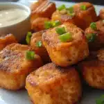 crispy bang bang salmon bites on a white plate