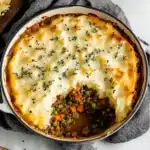 this is an image of a homemade shepherd's pie with cheese and meat in it