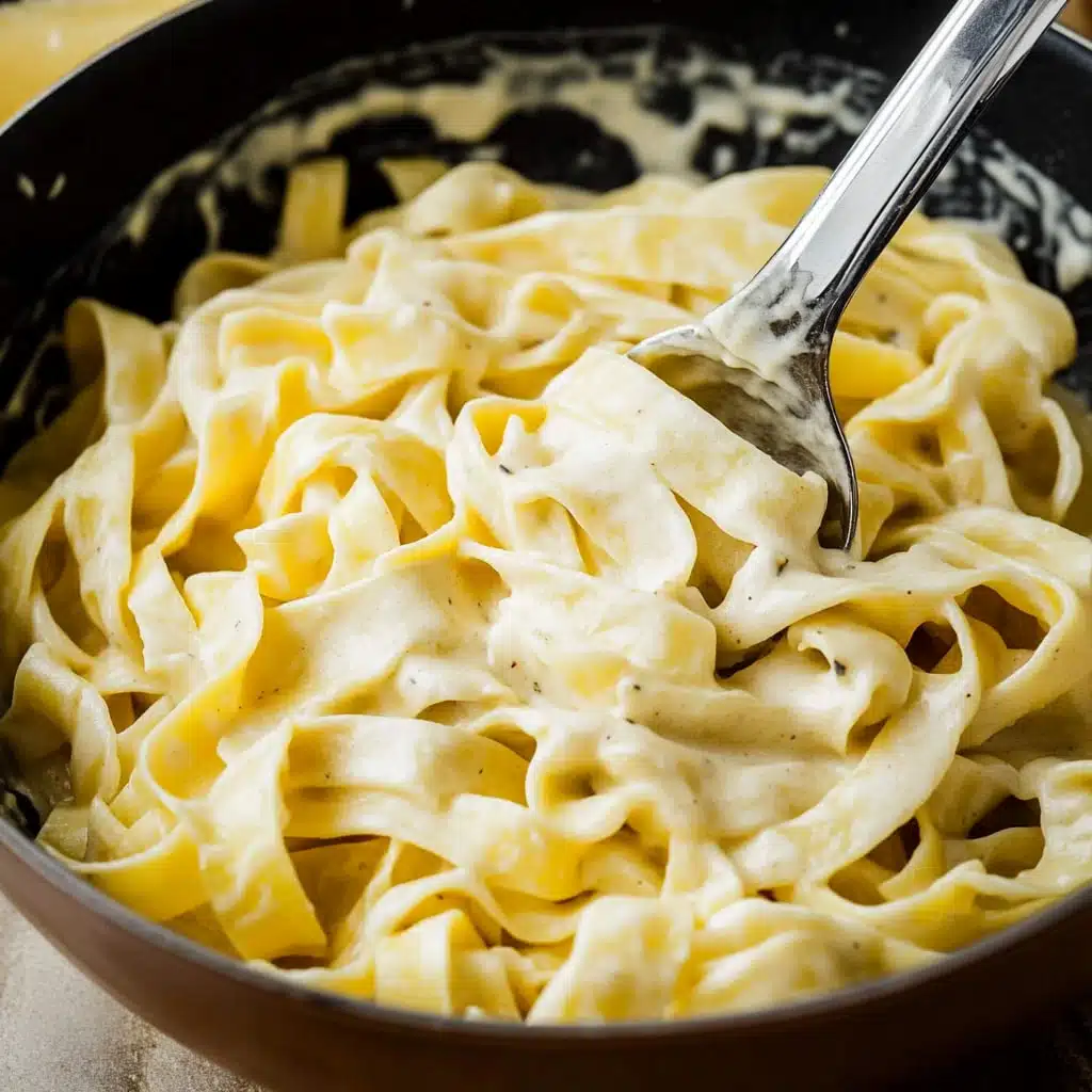 the best alfredo sauce in a pot with a wooden spoon