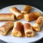 grilled cheese roll - ups on a white plate with text overlay that reads grilled cheese roll - ups