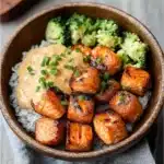 crispy bang bang salmon bites on a white plate