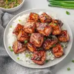 crispy honey garlic salmon bites with white rice and chopsticks