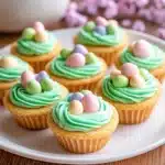 an easter cookie cupcake with green frosting and colorful eggs
