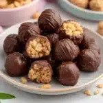 chocolate covered peanut butter balls are stacked on top of each other, with one bite taken out