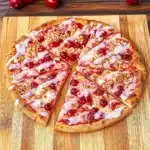 a cherry pie with crumbled toppings on it sitting on a table top