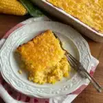 a close up of a casserole on a plate with the words easy corn casserole