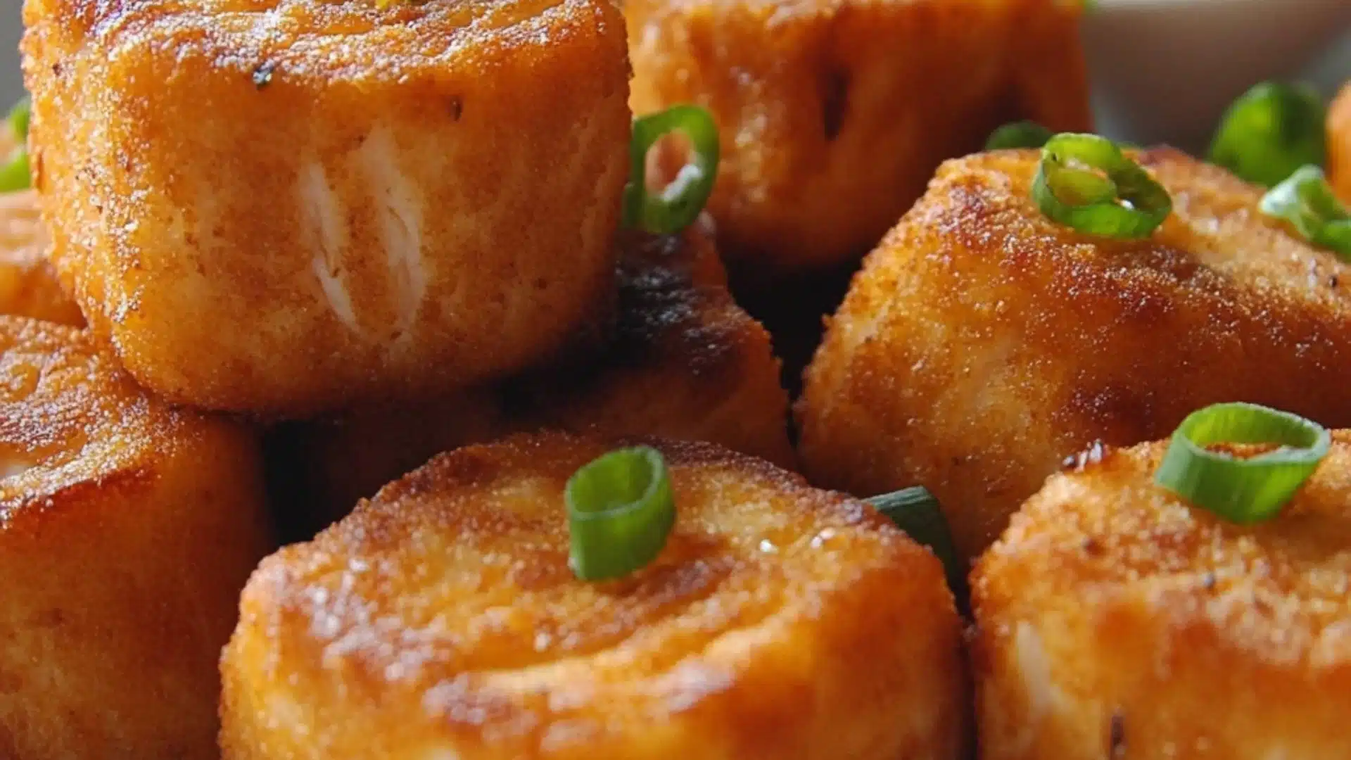 crispy bang bang salmon bites on a white plate