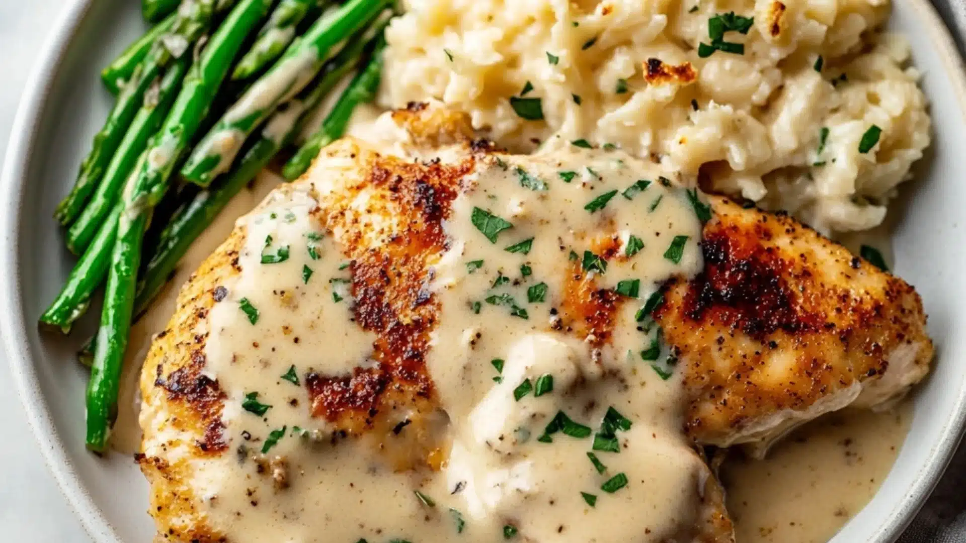 chicken with gravy sauce is being served in a white bowl