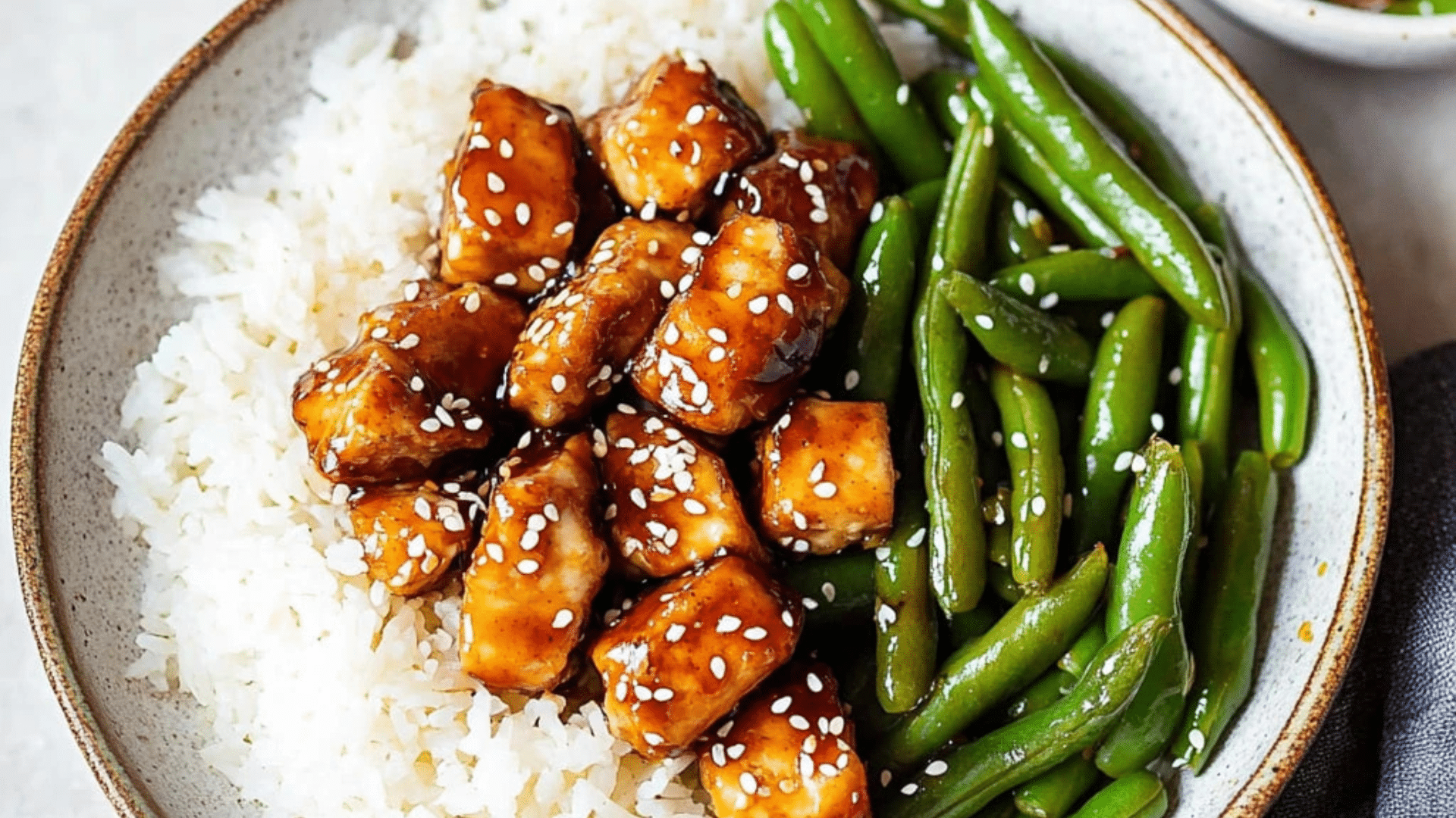 two plates filled with chicken and green beans