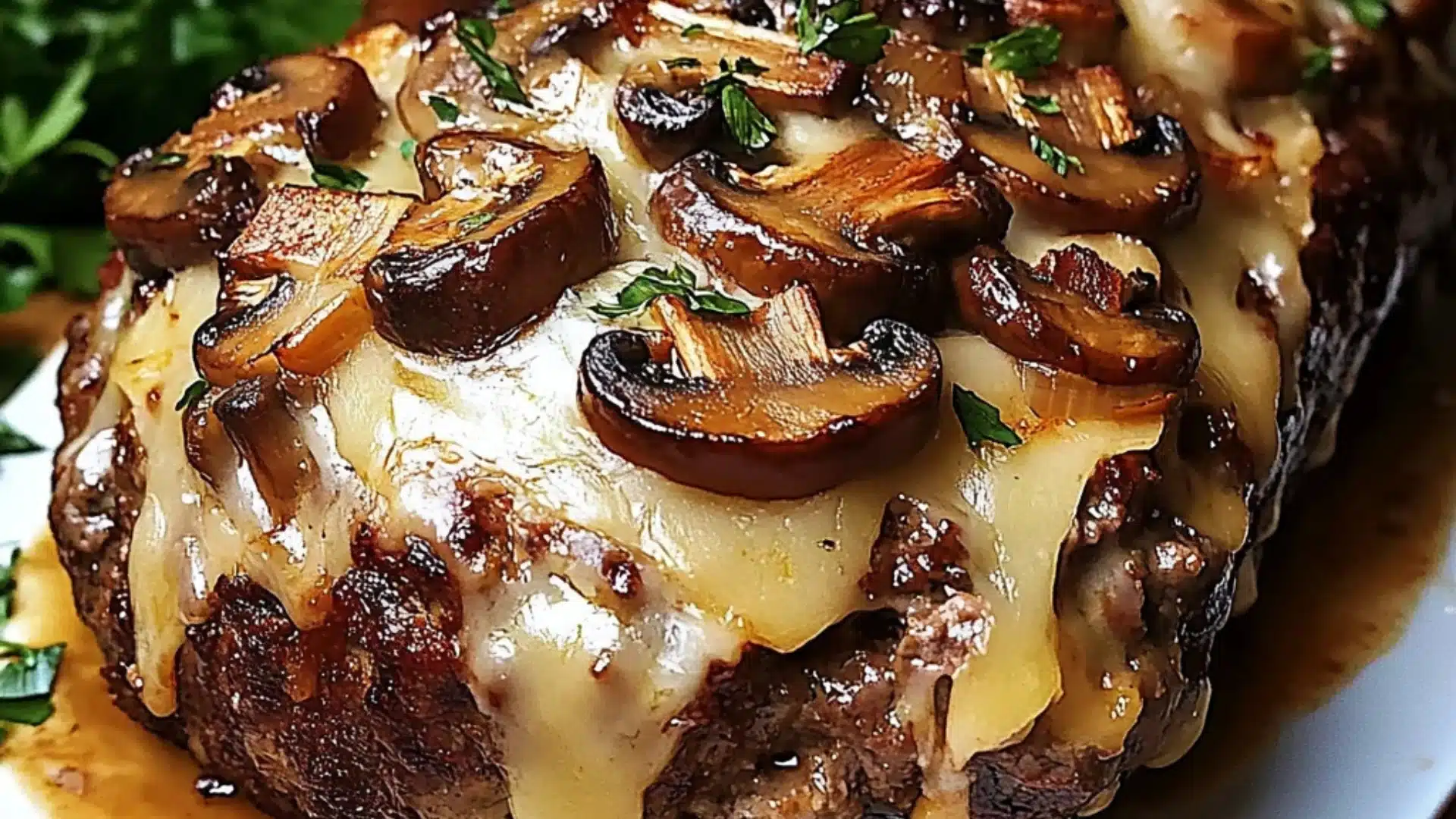 a piece of meatloaf with cheese and bacon on it sitting on a cutting board