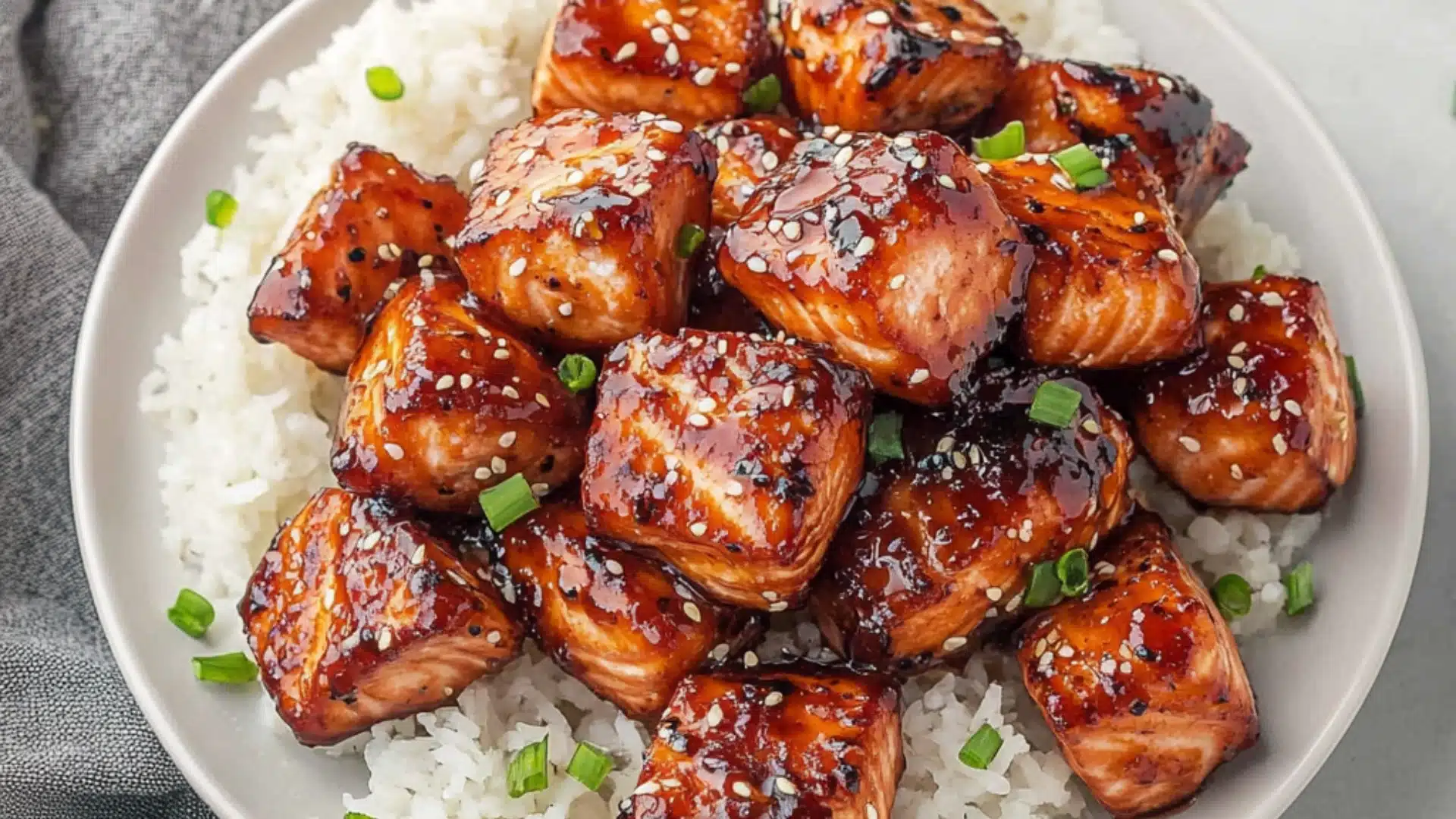 crispy honey garlic salmon bites with white rice and chopsticks