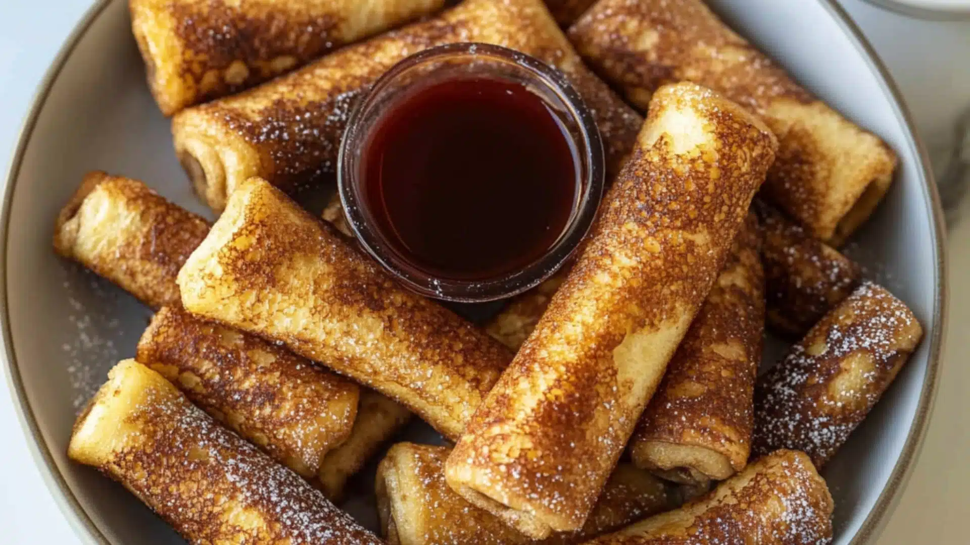 cinnamon roll french toast rolls on a white plate with the words cinnamon roll french toast rolls