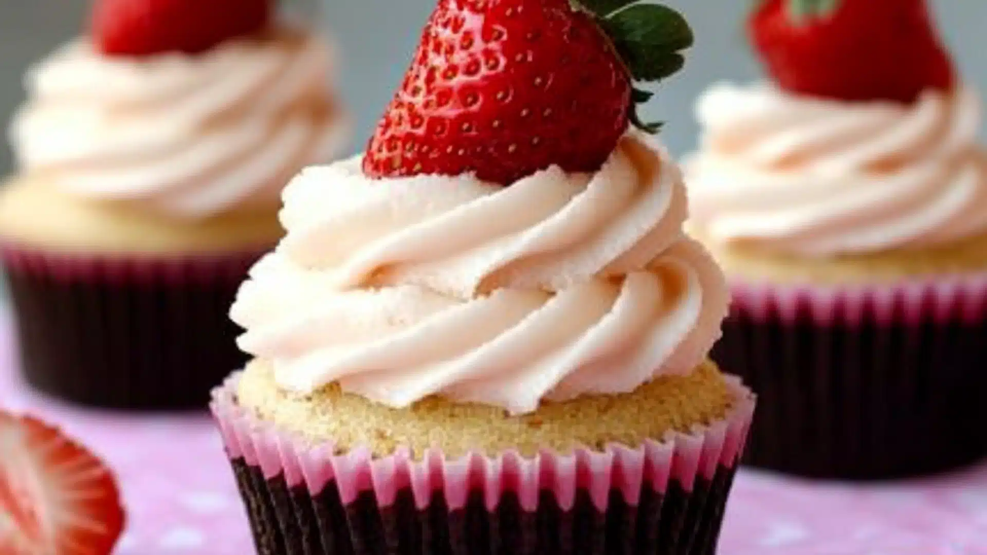 cupcakes with white frosting and strawberries on top