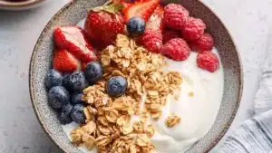 a bowl filled with fruit and yogurt on top of a white tablecloth