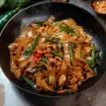 two pictures of stir fry noodles with chicken, peppers and green onions in a skillet