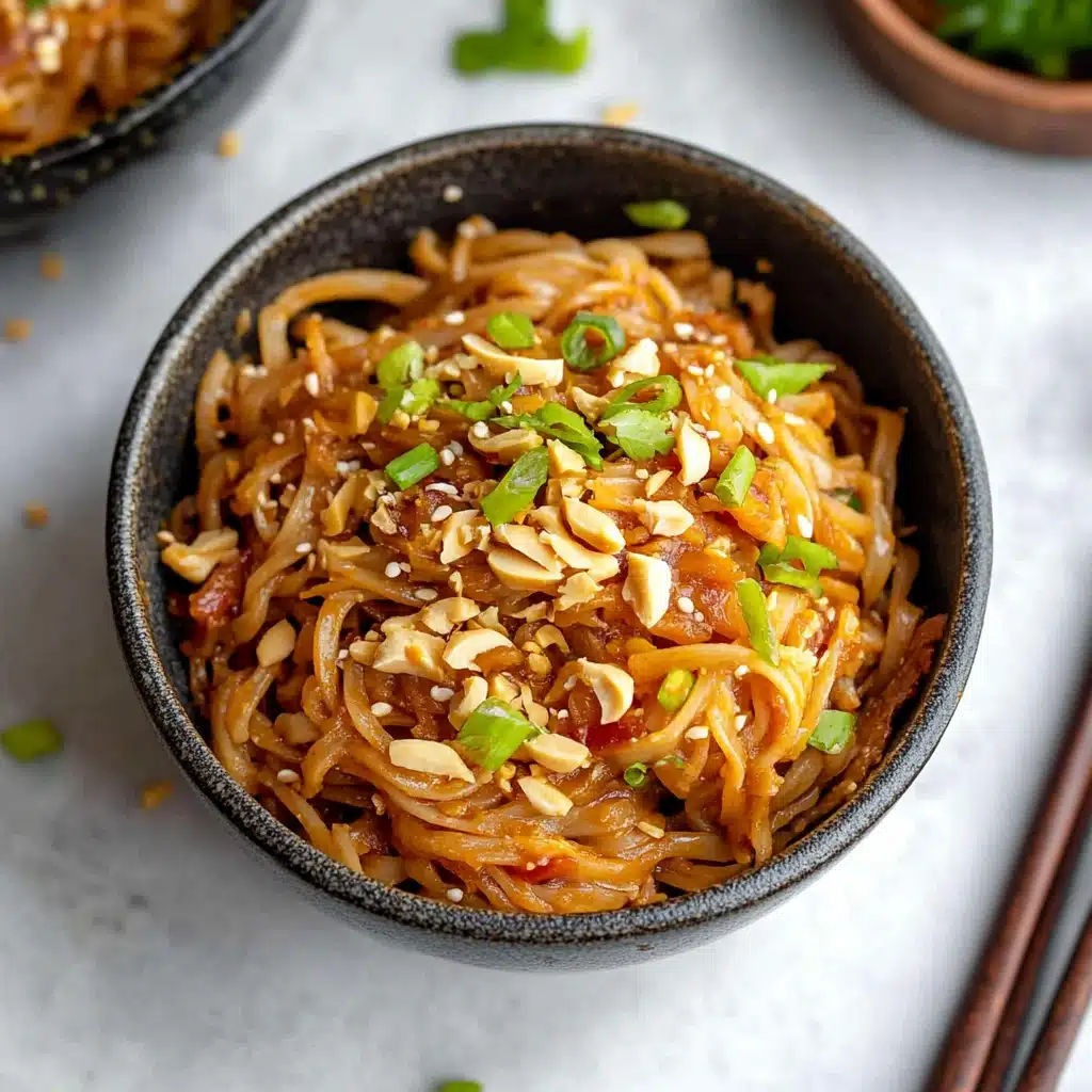 a white bowl filled with noodles and topped with green onions next to chopsticks