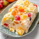 a piece of cake on a white plate with a cherry in the middle and one slice missing