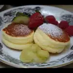 pancakes are stacked on top of each other with blueberries and syrup