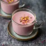 pink chai is served in a cup with cinnamons on top and the words authentic kashmiki pink chai above it
