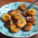 there are bananas that are on the plate with powdered sugar over them and then fried
