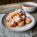 the funnel cake bites are covered in powdered sugar and sprinkled with icing