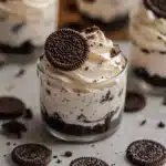 oreo cheesecake cups with cookies in the background and text overlay that reads easy no - bake oreo cheesecake cups