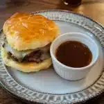 some biscuits with meat and cheese are on a baking sheet