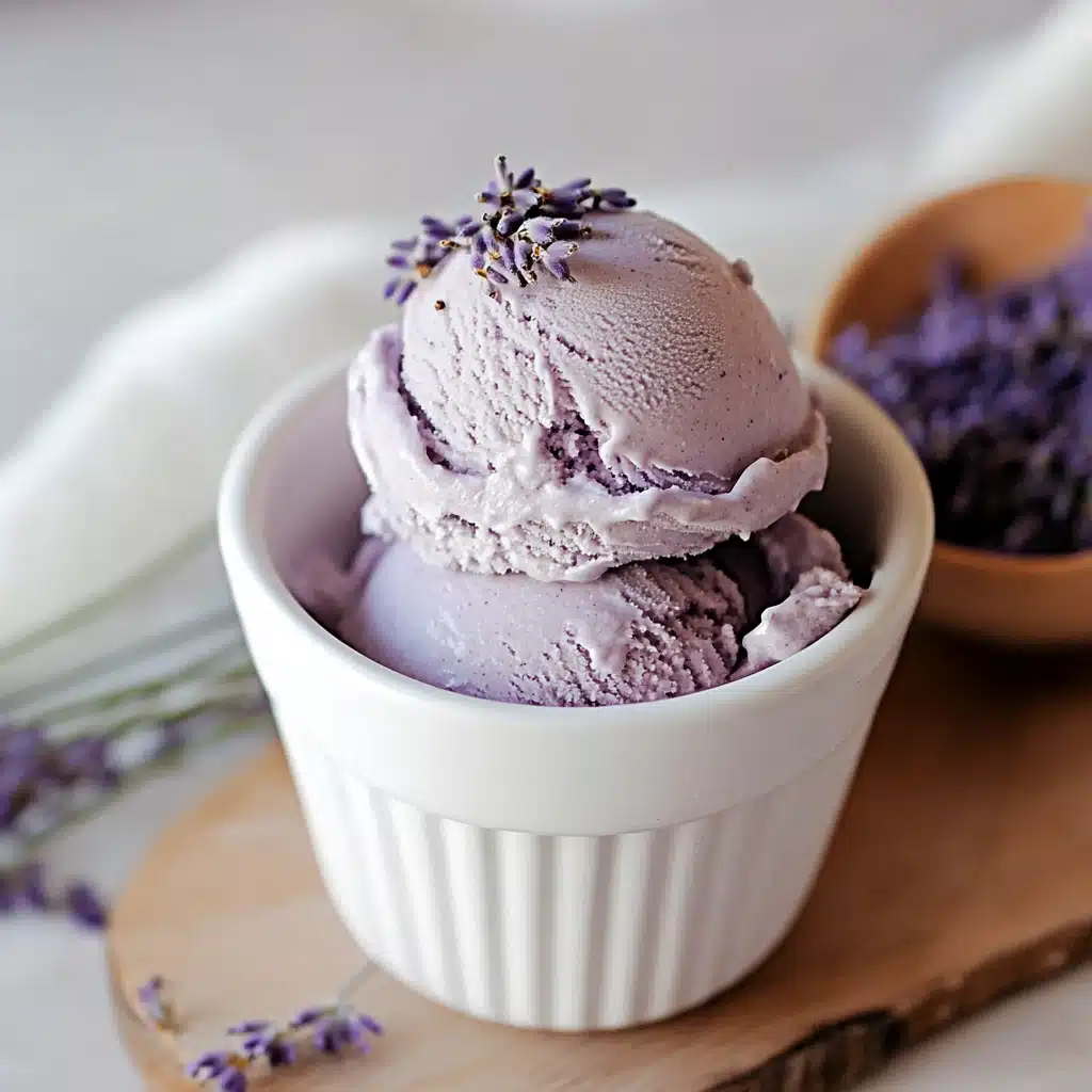 lavender ice cream in a white bowl with green leaves on top and the words lavender ice cream