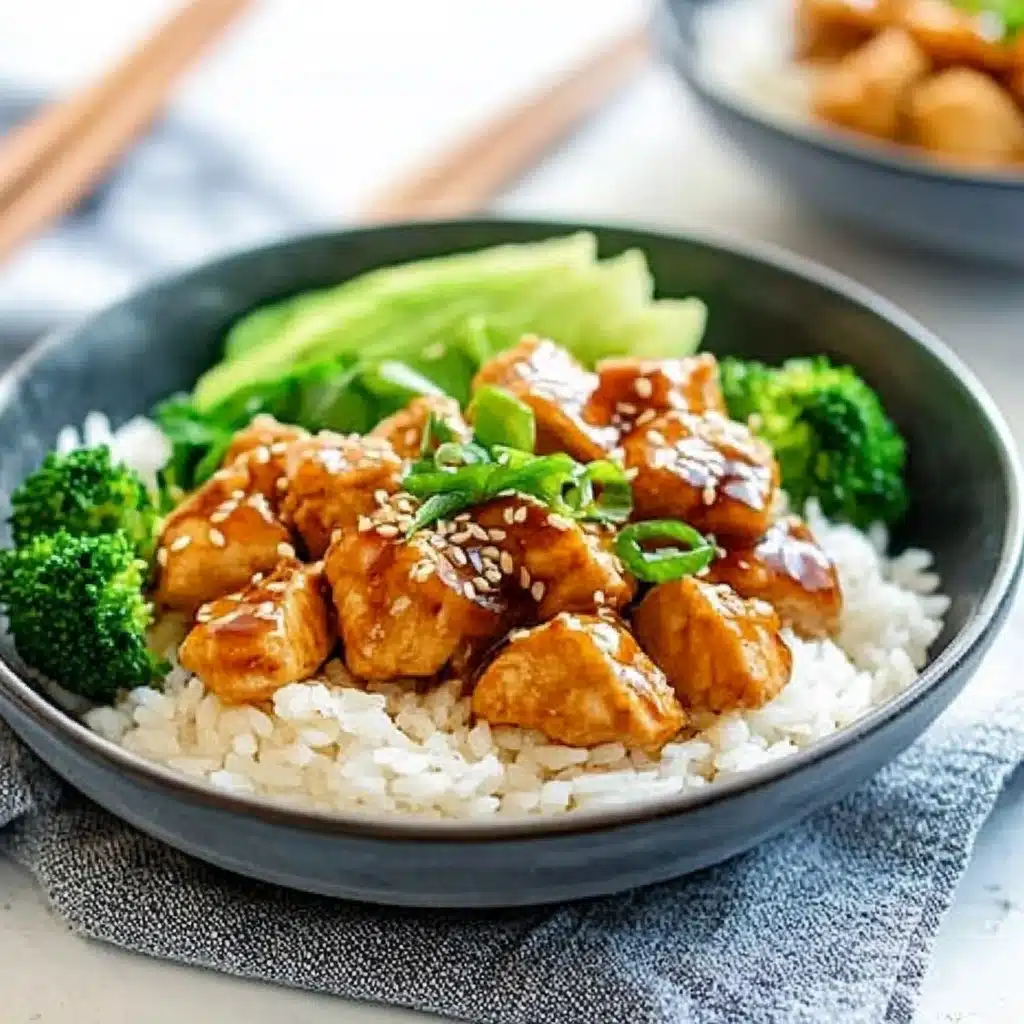 two bowls filled with rice, chicken and broccoli covered in teriyaki sauce