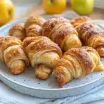 apple slices and cinnamon croissants are on a baking sheet before and after they have been baked