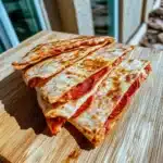 there are several different types of pizzas on this plate and in the middle one is cheese quesadillas