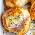 ham and cheese rolls in a white casserole dish