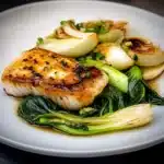 two pictures of fish with sauce and green onions