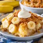 a close up of a plate of food with bananas and whipped cream on it next to a glass of milk