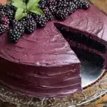 a cake with berries on top and the words delicious blackberry velvet gothic cake