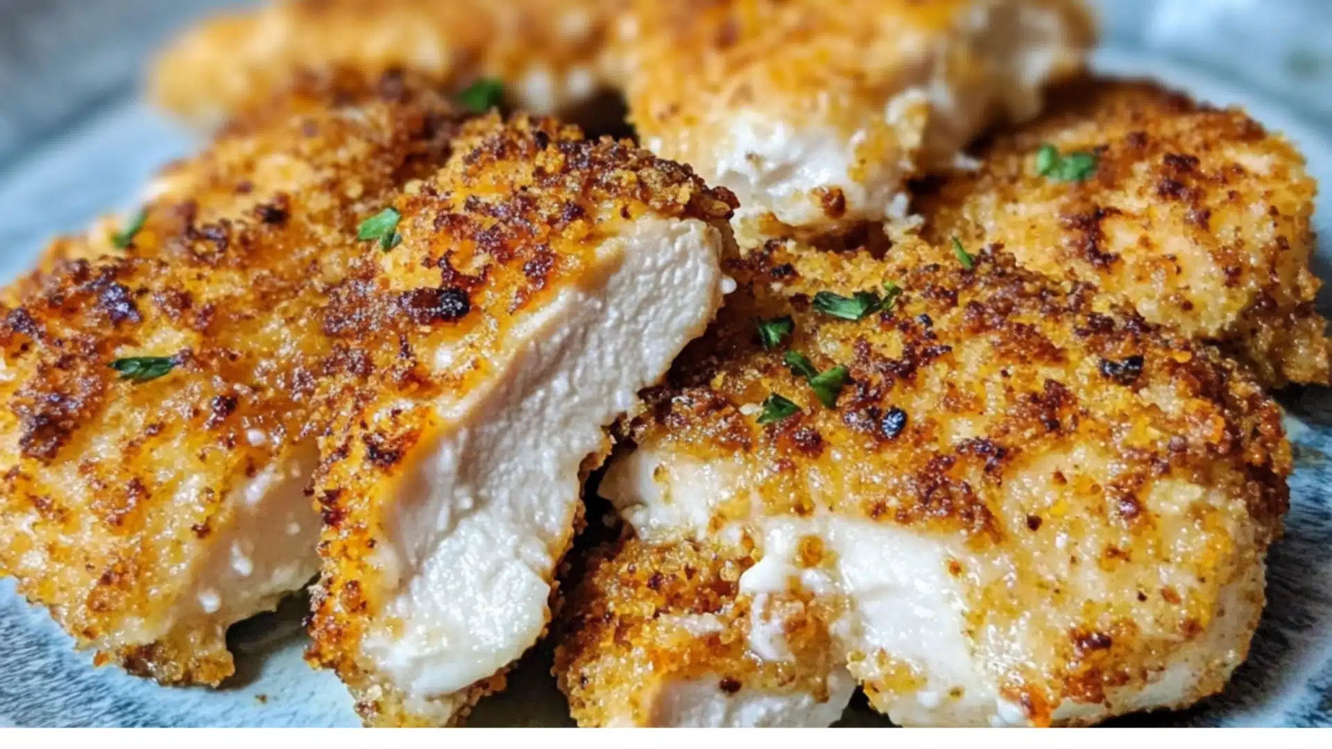 air fryer parmesan crusted chicken on a plate with sauce and herbs