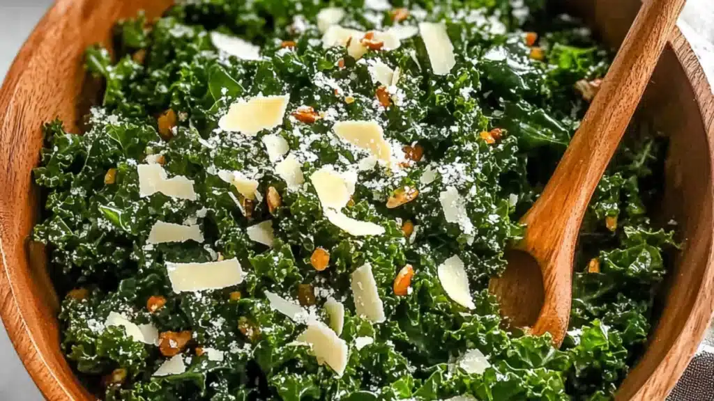 lemon parm kale salad on a white plate with spoons next to it