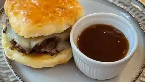 some biscuits with meat and cheese are on a baking sheet
