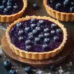 blueberry ganache tarts with fresh blueberries on the side and text overlay